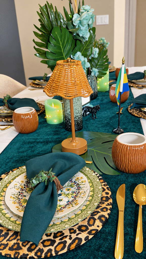 Floral plates on a leopard-print charger with a teal napkin, eucalyptus ring and woven lamp